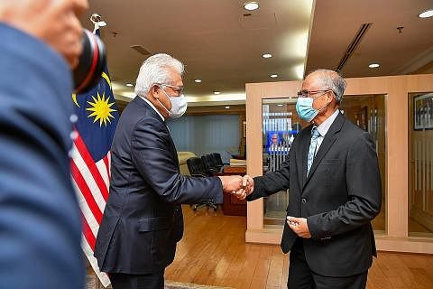 SIBUK BERTEMU RAKAN-RAKAN DI MALAYSIA: (Dari atas) Encik Masagos semasa mengunjungi Menteri Dalam Negeri Malaysia, Dato' Seri Hamzah Zainudin. Beliau, yang ditemani Ketua Eksekutif, Muis, Encik Kadir Maideen (gambar bawah kiri), turut bertemu Menteri