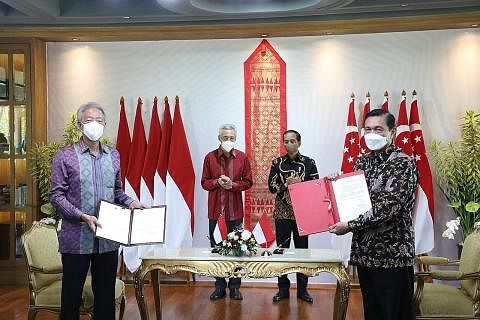METERAI PERJANJIAN: Encik Teo Chee Hean (depan, kiri) dan Menteri Penyelaras Ehwal Maritim dan Pelaburan Indonesia, Encik Luhut Pandjaitan (kanan), menandatangani perjanjian di Rahat Pemimpin bulan lalu. Turut hadir di pertemuan itu ialah (belakang d