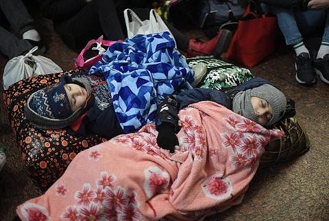 MANGSA PERANG: Kanak-kanak Ukraine ini tidur di atas lantai di stesen kereta api di pusat Lviv bagi melindungkan diri dari serangan tentera Russia. - Foto AFP
