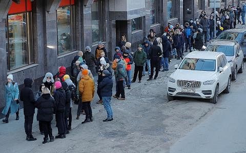 KESAN SEKATAN TERHADAP RUSSIA: Rakyat Russia beratur panjang menunggu giliran untuk mengeluarkan wang tunai dari ATM di Saint Petersburg Ahad lalu. Selepas menunggu berjam-jam, ada mendapati ATM ketiadaan wang. - Foto REUTERS