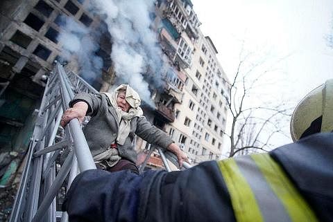 SELAMATKAN MANGSA SERANGAN: Penyelamat sedang membantu seorang wanita tua keluar daripada tempat kediamannya selepas bangunan yang dihuninya di Kyiv dibedil tentera Russia. - Foto REUTERS