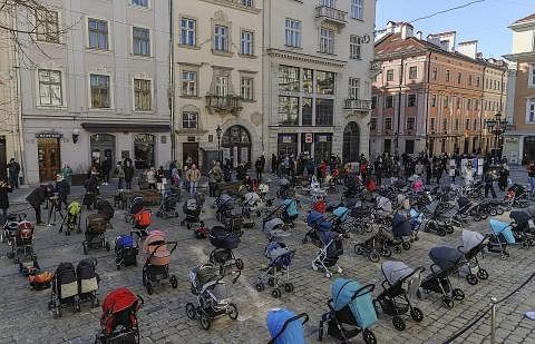 INGATAN PADA SI COMEL: Lebih 100 kereta sorong bayi disusun semasa satu persembahan yang dinamakan "Harga Peperangan" di pusat bandar Lviv, Ukraine, kelmarin. Ia sebagai memperingati lebih 100 kanak-kanak yang terbunuh akibat serangan Russia ke atas 