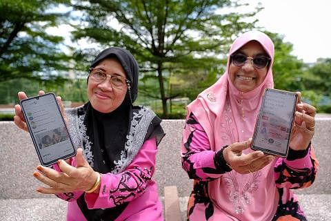 SUDAH TIDAK TERKIAL-KIAL: Cik Asmah Talib, 64 tahun (kiri) dan temannya Cik Salmabee Abdul Kadir, 66 tahun, yang telah menghadiri bengkel celik digital warga emas Jom Surf! Januari lalu, menunjukkan aplikasi HealthHub dan SingPass dalam telefon bimbi