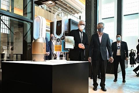 TINJAU TEKNOLOGI: Encik Lee Hsien Loong (kanan) meninjau pameran teknologi Dyson di perasmian ibu pejabat global syarikat itu di bangunan St James Power Station semalam. Bersamanya ialah Encik James Dyson, pengasas dan pengerusi Dyson. - Foto BH oleh