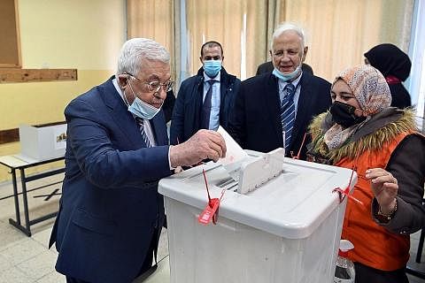 BUANG UNDI: Presiden Palestin, Encik Mahmoud Abbas (kiri). membuang undi untuk pilihan raya majlis perbandaran dan gabenor tempatan. - Foto REUTERS