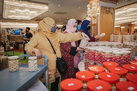 BOLEH PILIH: Jualan kuih di The Istana Ballroom di Tanjong Katong Complex membolehkan pelanggan memilih ratusan jenis kuih dan kek. - Foto-Foto BH oleh NUR DIYANA TAHA RANGKA KHEMAH DIPASANG: Para pekerja dilihat memasang rangka khemah bagi bazar 'Wa