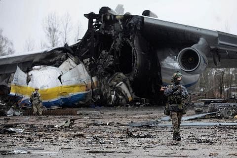 MUSNAH: Seorang anggota tentera Ukraine berjalan di hadapan pesawat kargo Antonov An-225 Mriya, kapal terbang terbesar di dunia, yang telah dimusnahkan oleh tentera Russia di penempatan Hostomel. Tentera negara itu telah merampas semula semua kawasan