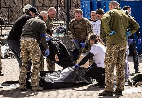 KORBAN PERANG BERTERUSAN: Askar Ukraine mengangkat mayat korban serangan roket yang membunuh sekurang-kurangnya 35 penduduk kelmarin di stesen kereta api di Kramatorsk, timur Ukraine, yang digunakan bagi memindahkan penduduk. - Foto AFP