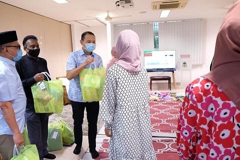 BERI HABUAN: Encik Fahmi Aliman (tiga dari kiri) menghulurkan beg habuan kepada anak-anak yatim Darul Ihsan sebelum berbuka puasa dengan mereka kelmarin. Bersama beliau ialah (dari kiri), Timbalan Pengurus Besar BigFoot Logistics, Encik Farid Aliman,