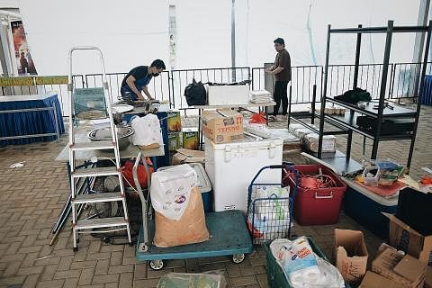 HENTI OPERASI: Pengendali gerai membawa pulang barangan jualan dari bazar 'Ramadan Fiesta 2022' di Pasir Ris semalam susuli arahan bazar dihentikan kerana beroperasi tanpa permit. - Foto BH oleh HARITH MUSTAFFA