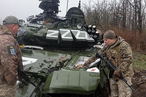 PERIKSA KERETA KEBAL RUSSIA: Beberapa askar Ukraine sedang memeriksa sebuah kereta kebal Russia yang rosak di kawasan Donetsk yang kini menghadapi serangan besar-besaran oleh tentera Russia. - Foto REUTERS
