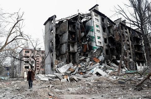 ROSAK TERUK: Seorang penduduk sedang berjalan di sebuah bangunan kediaman yang rosak teruk di bandar pelabuhan Mariupol yang dikatakan hampir dikuasai tentera Russia. - Foto REUTERS