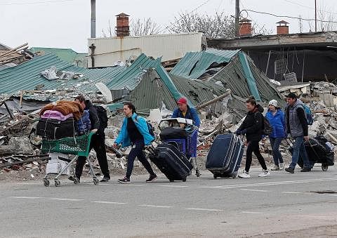 LARIKAN DIRI: Penduduk di Mariupol bergegas meninggalkan kediaman mereka setelah bandar pelabuhan timur Ukraine itu teruk diserang tentera Russia. - Foto REUTERS