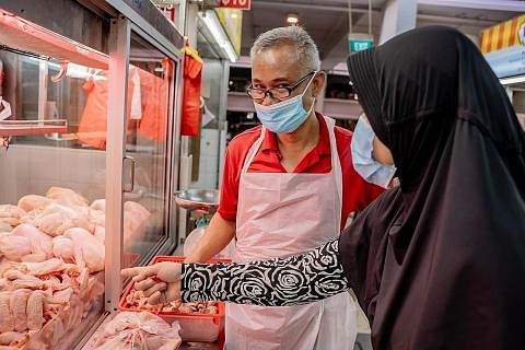 TIMBANG PILIHAN: Pemilik gerai Mohamed Ali Fresh & Frozen, Encik Husni Hashim berkata beliau akan meninjau keadaan sebelum mengambil stok ayam beku tambahan daripada pembekal lain dan menaikkan harga ayam beku yang dijual. - Foto BH oleh NUR DIYANA T
