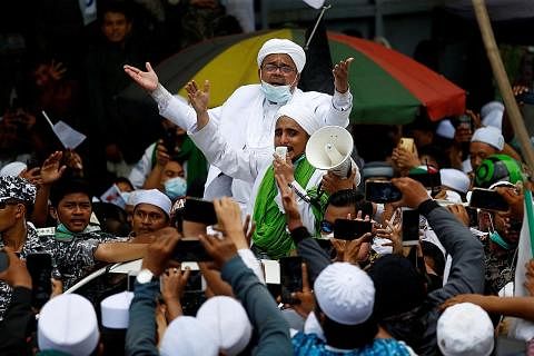 DIBEBASKAN BERSYARAT: Habib Rizieq Shihab (berpelitup) disambut penyokongnya di Tanah Abang, Jakarta, pada November 2020. Beliau dihukum penjara empat tahun Jun tahun lalu tetapi dibebaskan lepas menjalani hukuman lebih setahun. - Foto fail