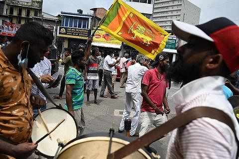 RAIKAN PEMILIHAN: Penyokong Encik Ranil Wickremesinghe meraikan pemilihan beliau sebagai presiden baru negara itu di ibu kota Colombo. - AFP