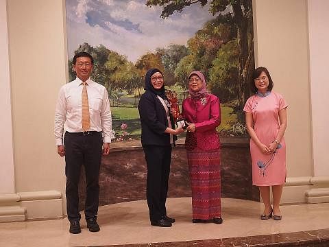 PENGIKTIRAFAN TERTINGGI: Cik Nirmala (dua dari kiri) menerima Anugerah Presiden bagi Jururawat dari Presiden Halimah yang turut dihadiri Encik Ong (kiri) dan Cik Koh.