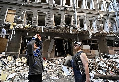 DI TENGAH-TENGAH KEMUSNAHAN: Pekerja dilihat berada di medan legar sebuah pusat pejabat dan membeli belah di tengah Kharkiv, Ukraine, pada 27 Julai lalu, yang ranap akibat serangan Russia. - Foto AFP