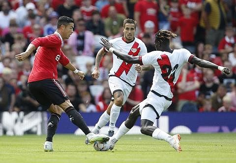 DAPAT SORAKAN PENYOKONG: Christiano Ronaldo (jersi merah) dicabar oleh pemain Rayo Vallecano Pathe Ciss dalam perlawanan latihan pramusim di Old Trafford kelmarin, yang berakhir dengan seri 1-1. Beliau diberi sorakan hebat oleh penyokong apabila tutu