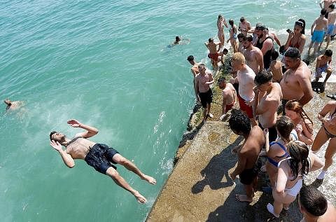 PANAS TERIK: Seorang lelaki terjun ke laut sewaktu berlaku gelombang haba di Brighton, Britain, pada 19 Julai lalu.
