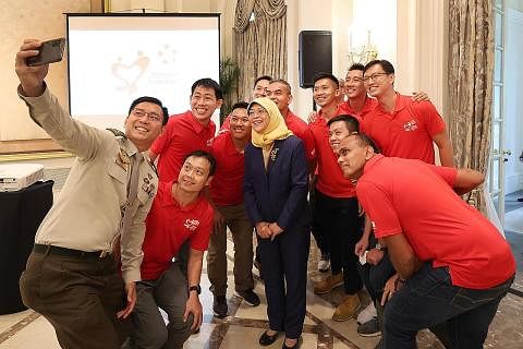 BERI PENGHARGAAN: Presiden Halimah Yacob bergambar selfie bersama anggota jawatankuasa penganjur NDP 2022 di majlis jamuan penghargaan bagi penganjur utama dan peserta serta sukarelawan perbarisan di Istana semalam. - Foto MCI