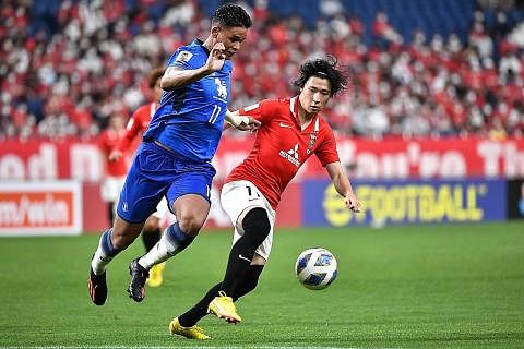 BERAKSI: Irfan Fandi (kiri) bersaing untuk berebut bola dengan pemain Urawa, Yusuke Matsuo sewaktu kejuaraan Liga Juara-Juara AFC. - Foto AFP