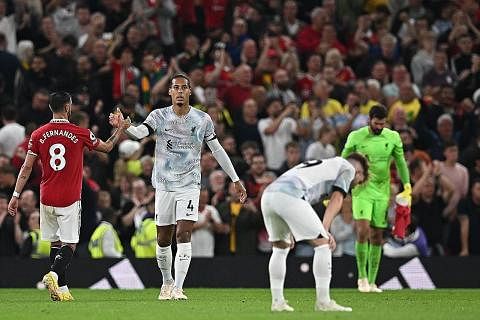 RAIKAN GOL: Jadon Sancho (tengah) meraikan gol selepas membuka tirai jaringan bagi Manchester United di awal perlawanan. KECEWA: Sedang penyokong United gembira dengan kemenangan pasukan kegemaran mereka, para pemain Liverpool (berjersi putih) bak ti