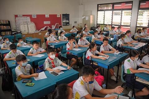 ADA PAKAI PELITUP, ADA TAK PAKAI: Murid-murid di Sekolah Rendah Poi Ching di Tampines mengikuti kelas, dengan ada di kalangan mereka memilih untuk tidak memakai pelitup. - Foto BH oleh MARK CHEONG