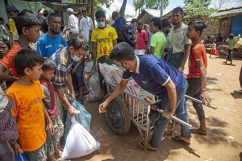 MOHON BANTUAN SEDUNIA: Pelarian Rohingya yang ditemui pada 24 Ogos lalu di kem penempatan Kutubpalang di Ukhiya Cox Bazar, Bangladesh, dilihat mengambil kampit berisi bahan makanan yang diagihkan kepada penghuni di kem tersebut. Tarikh 25 Ogos menand