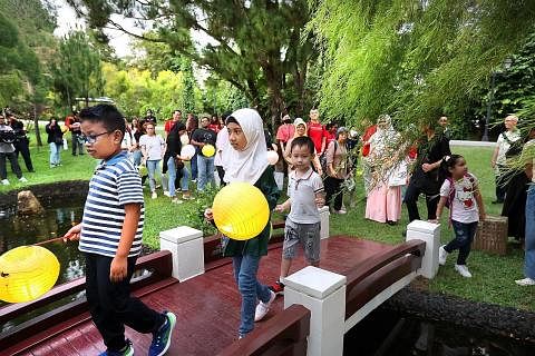 CUKUP SERONOK: Kanak-kanak yang terlibat sama dalam acara "Berkelah Pertengahan Musim Luruh" kelihatan begitu seronok memegang tanglung yang mereka hiasi semasa di Istana. CUKUP MESRA: Encik Muhammad Taufiq (kiri) bersama isterinya Cik Nuur Siti Shah