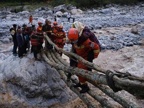 HULUR BANTUAN: Pekerja penyelamat memindahkan penduduk di daerah Luding, pusat gempa kuat yang melanda China kelmarin. Sekurang-kurangnya 46 orang terbunuh sejauh ini. - Foto EPA-EFE