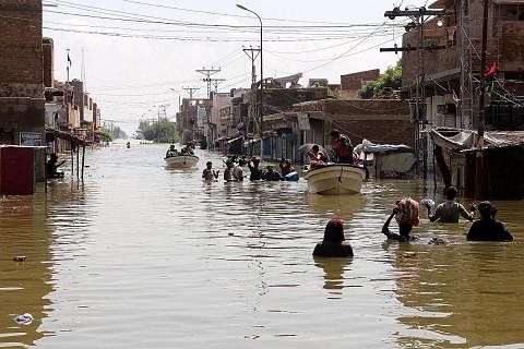 CUBA SELAMATKAN DIRI: Orang ramai yang terjejas akibat banjir kilat berpindah ke kawasan yang lebih tinggi di kawasan Khairpur Nathan Shah, daerah Dadu, wilayah Sindh, Pakistan. - Foto-foto EPA-EFE KESIHATAN DIUTAMAKAN: Pekerja kesihatan memberikan v