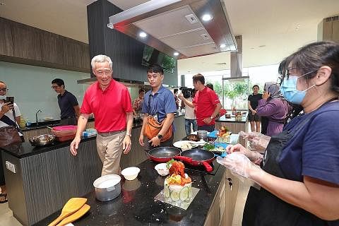 KEMUDAHAN MENARIK: Perdana Menteri Encik Lee Hsien Loong melawat Studio Kulinari yang sedang mengendalikan bengkel membuat kek nasi lemak di Kelab Masyarakat Fernvale.