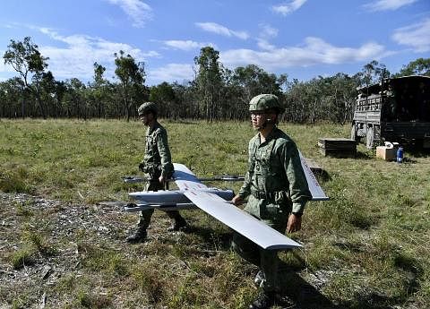 USAHA PERISIKAN: Dua anggota SAF kelihatan menyediakan UAV V-15 di satu kawasan latihan di Shoalwater Bay, Queensland, Australia kelmarin. - Foto BH oleh DESMOND FOO