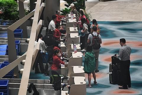 SUDAH DIUBAH SUAI:(Kiri) Penumpang mendaftar masuk atau 'check in' di Terminal 2 Lapangan Terbang Changi semalam. (Atas) Penumpang melepasi imigresen di Terminal 2 Lapangan Terbang Changi semalam. - Foto-foto BH oleh CHONG JUN LIANG