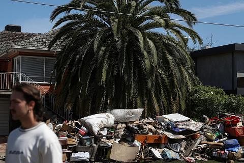 ANGKARA BANJIR: Pemilik rumah di bandar Maribyrnong di Melbourne meletakkan perabot dan barangan rumah yang rosak akibat banjir di luar rumah mereka. - Foto REUTERS