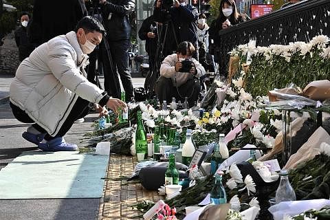 PERINGATI MANGSA: Seorang pengunjung meletakkan minuman sebagai memperingati mangsa tragedi rempuhan ketika pesta Halloween di Itaewon. - Foto AFP