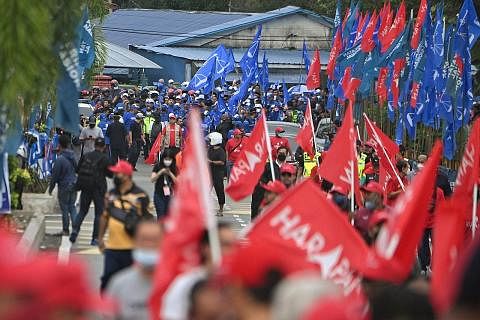 BERSAING SENGIT: Penyokong Pakatan Harapan (berbaju merah) dan Barisan Nasional (berbaju biru) menuju pusat penamaan calon di Gombak pada 5 November. Dua gabungan itu, dan Perikatan Nasional (PN), dijangka bertanding sengit bagi kerusi Parlimen Selan