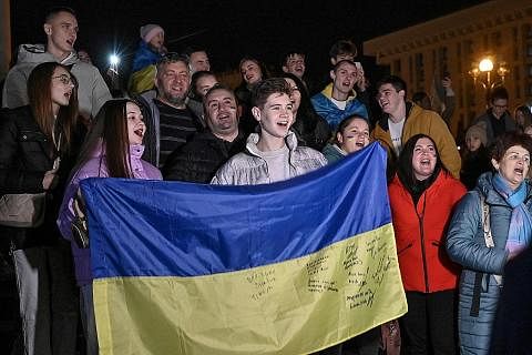 SAMBUTAN BERMAKNA: Penduduk Kherson memegang bendera Ukraine semasa berhimpun di Dataran Maidan bagi merayakan pembebasan Kherson, di Kyiv, kelmain, di tengah-tengah pencerobohan Russia ke atas Ukraine sejak Februari tahun ini. - Foto AFP