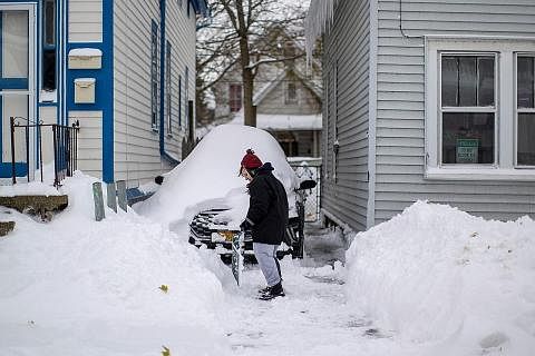 DIBENAM SALJI: Seorang wanita dilihat cuba membersihkan kawasan rumahnya daripada timbunan salji akibat ribut salji yang melanda kawasan Buffalo, New York, Amerika Syarikat, sejak beberapa hari lalu. - Foto REUTERS