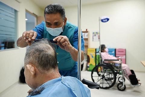 GUNTING RAMBUT: Sebulan sekali, Encik Taha meluangkan masa di Hospital Masyarakat Jurong untuk menggunting rambut pesakit yang tinggal di sana untuk jangka masa panjang. (Gambar sisipan) menunjukkan Encik Taha sedang menggunting rambut seorang pesaki