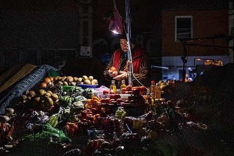 NIAGA DALAM GELAP: Penjual ini teruskan niaga dan membuka gerainya di sebuah pasar Bessarabka di pusat bandar Kyiv sekalipun di tengah-tengah bekalan elektrik terputus yang kerap berlaku sejak pencerobohan Russia ke atas Ukraine. - Foto AFP