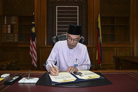 MULA TUGAS: Datuk Anwar, yang mengenakan baju Melayu lengkap bersamping, memulakan tugas hari pertamanya sebagai perdana menteri Malaysia di Pejabat Perdana Menteri di Putrajaya semalam. - Foto REUTERS