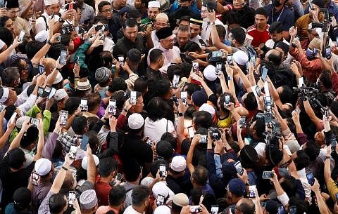 DIKERUMUNI: Datuk Seri Anwar Ibrahim (baju kurung merah jambu) dikerumuni orang ramai setibanya di Masjid Putra sekitar 1.01 petang bagi menunaikan solat Jumaat. - Foto REUTERS