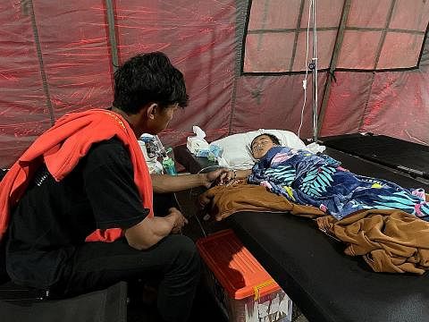 JAGA ADIK: Encik Salman Alfarisi, menemani adiknya, Azka, yang terselamat meskipun berada di bawah timbunan runtuhan selam a dua hari selepas berlaku gempa bumi. - Foto REUTERS