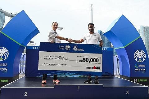 SUMBANG DANA: Presiden Persatuan Olahraga Singapura (SAA), Encik Lien Choong Luen (kiri) menerima cek $50,000 daripada Encik Santoz Kumar daripada The Ironman Group. - Foto SCSM