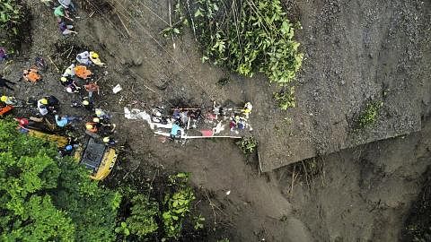 USAHA MENYELAMAT: Gambar dari udara yang dikeluarkan pejabat pertahanan awam Colombia menunjukkan kejadian tanah runtuh yang menimbus sebuah bas di kawasan Pueblo Rico. - Foto AFP