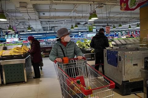 DIBENARKAN SEMULA: Pelanggan berpelitup di sebuah pasar raya di Beijing, sedang pihak berkuasa mengumumkan orang ramai tidak perlu menunjukkan ujian Covid-19 negatif untuk memasuki tempat awam seperti pusat beli-belah dan pasar raya mulai kelmarin. -