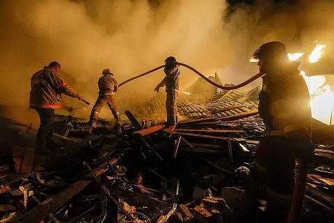 KEBAKARAN AKIBAT SERANGAN: Anggota bomba cuba memadamkan api di tengah-tengah runtuhan bangunan di Donesk semalam. - Foto REUTERS