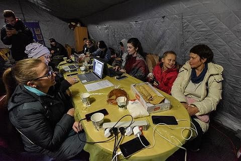 MANFAAT BEKALAN KECEMASAN: Pemerintah Ukraine menyediakan bekalan elektrik untuk penduduk bagi membolehkan mereka mengecas perkakas elektrik, komputer dan telefon bimbit dan berhubungan dengan dunia luar. - Foto-Foto EPA-EFE GELAP-GELITA: Penduduk Ky